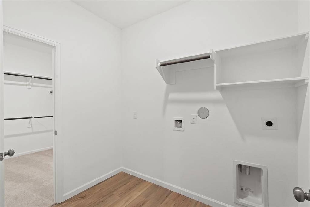 Utility Room with wood flooring, shelving and hanging bar to ensure doing laundry is a breeze!
