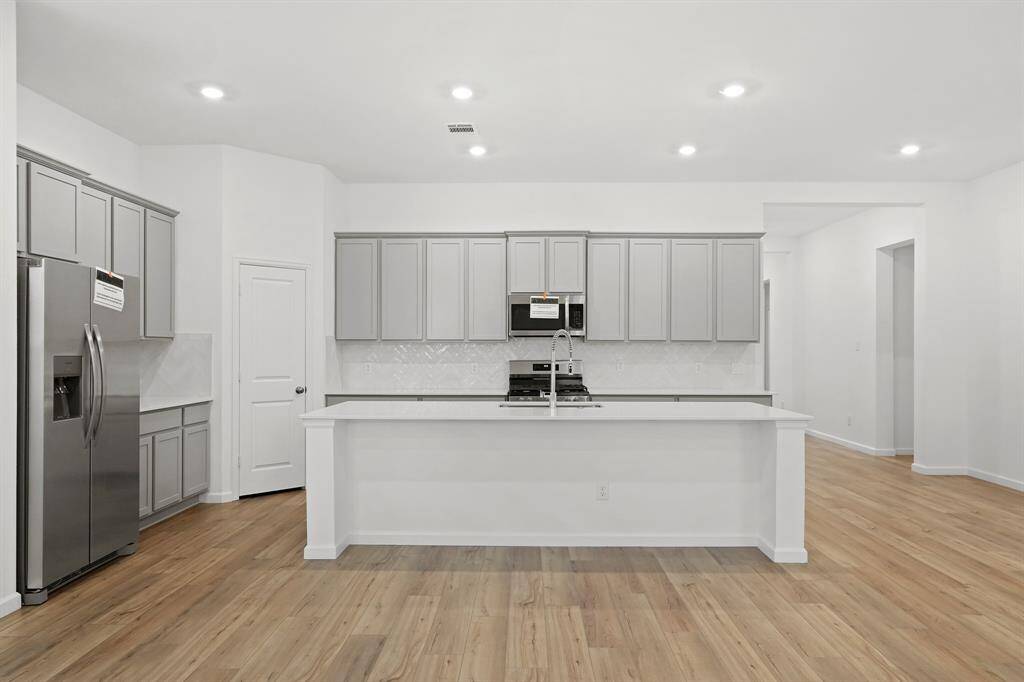 Gourmet Kitchen boasts Quartz countertops, extended island with Breakfast Bar for additional seating and abundance of storage and counter space.