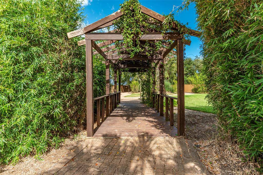 Peaceful Living with Stroll under the canopy of the peaceful Bambo lined walkway leads form the pool area to the large backyard.