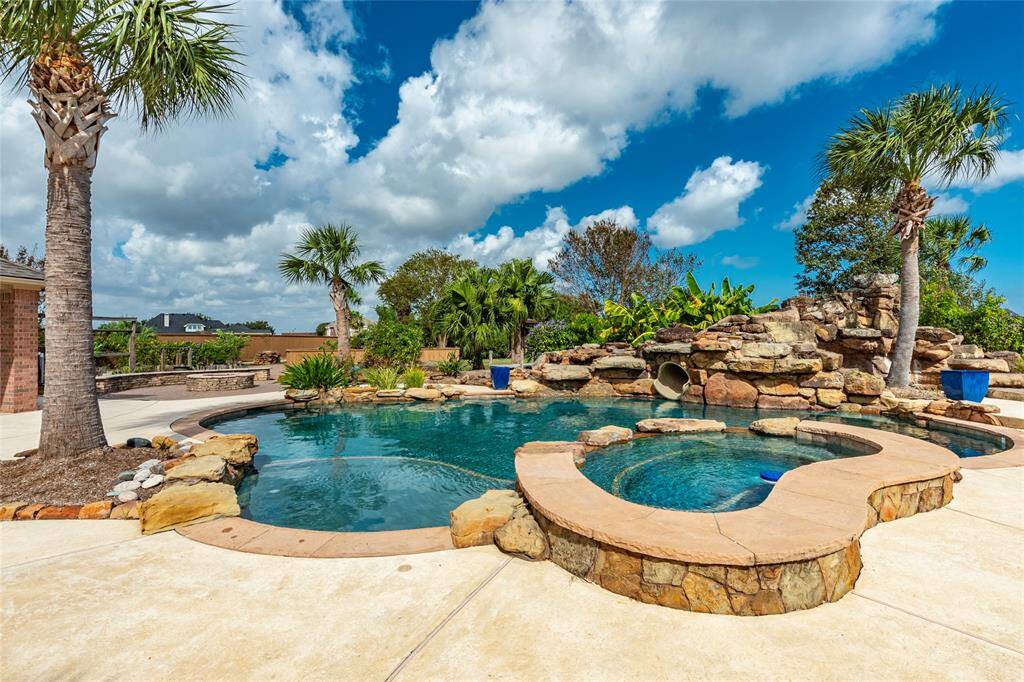 Relaxing Lifestyle Retreat!  Surrounded by captivating water features, this backyard oasis also includes an outdoor shower, poolside bath, and a cozy firepit — ideal for relaxing or hosting unforgettable gatherings.