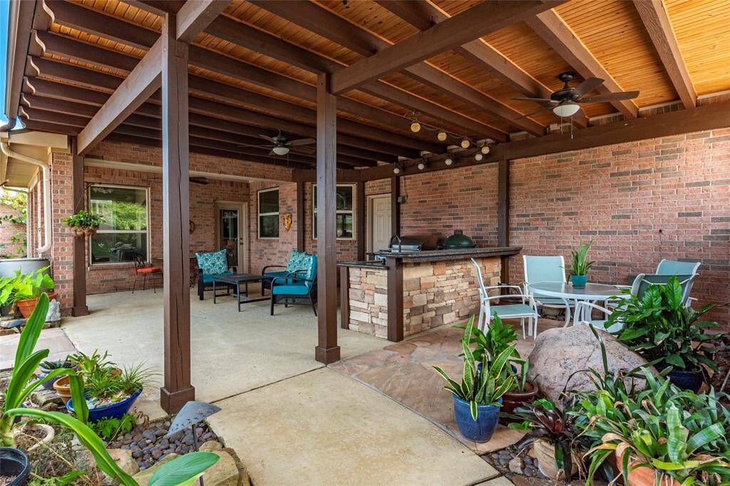 The Perfect Package for Entertaining! The outdoor kitchen under the first back covered patio is a chef’s dream—featuring a DCS stainless gas grill, Big Green Egg, and granite bar top.