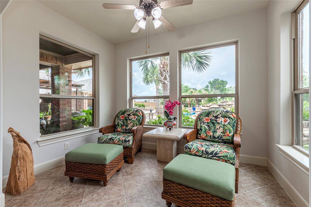 Just off the breakfast area, the tiled sunroom provides a serene retreat with relaxing views of the lushly landscaped backyard and sparkling swimming pool. This peaceful space, bathed in natural light, offers the perfect spot to unwind, enjoy a book, or savor the beauty of your outdoor oasis year-round.