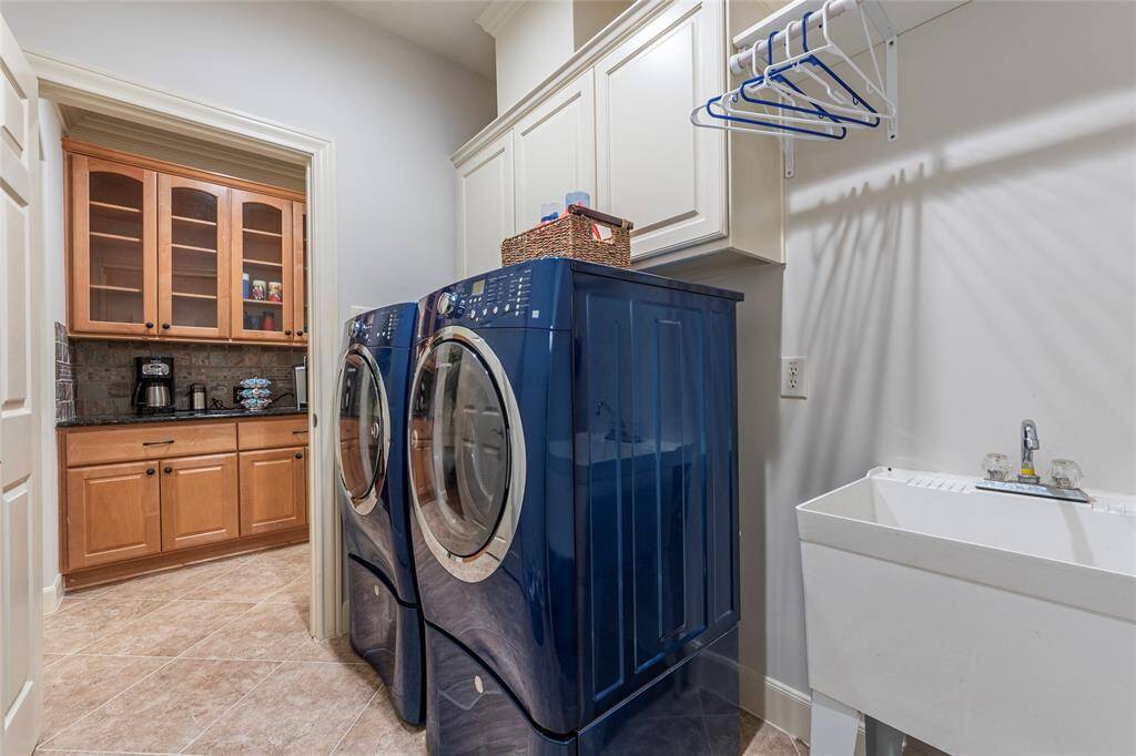 Spacious laundry room awaits, equipped with a built-in ironing board, large utility sink and a unique 'laundry chute' leading from the second floor, adding practicality to your daily chores.