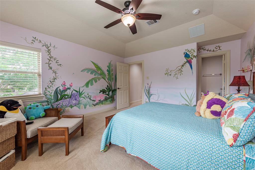 Spacious secondary bedroom, showcasing a custom hand-painted mural with intricate details, features a large walk-in closet, a full en suite bathroom.