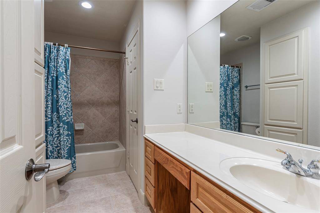 The en suite bath features elegant tile flooring and a fully tiled shower/tub combination, complemented by a convenient linen closet and laundry chute, offering both style and practicality.