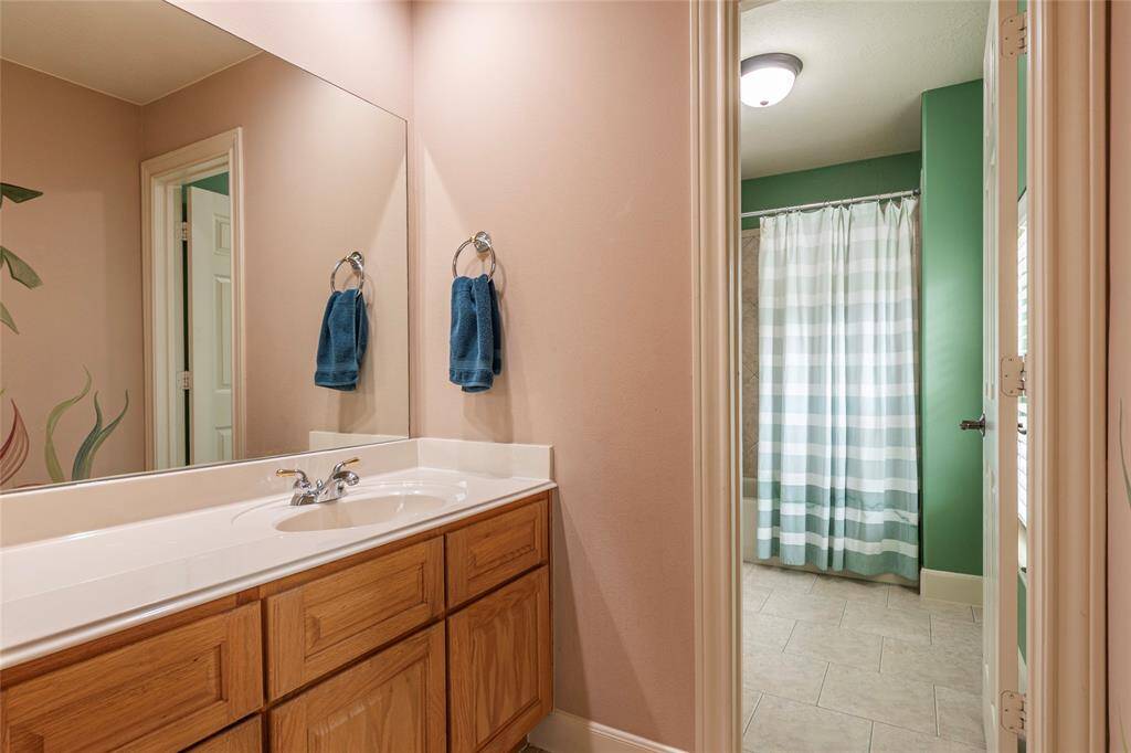 The Jack and Jill bathroom serves two secondary bedrooms upstairs, both featuring a private vanity, offering a perfect blend of character and convenience.