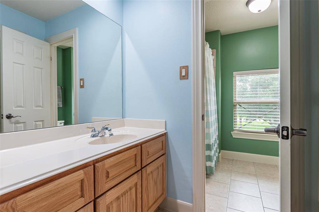 The Jack and Jill bathroom serves two secondary bedrooms upstairs, both featuring a private vanity, offering a perfect blend of character and convenience.