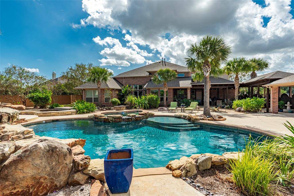 Backyard Paradise Meets Everyday Luxury! Tropical charm abounds with Chinese Fan, Date, Pindo, Windmill, Sago, Sabal, and Mediterranean Fan Palms. Two covered back patios surround home and offer the perfect setting for gatherings, while the fully equipped outdoor kitchen makes entertaining a breeze.