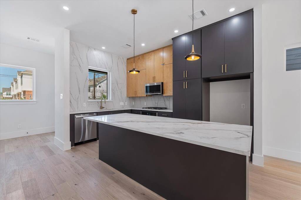 Kitchen with CUSTOM CABINETRY, kitchen island, abundant storage and GE PROFILE Appliances that include Range top, oven, microwave, and dishwasher!