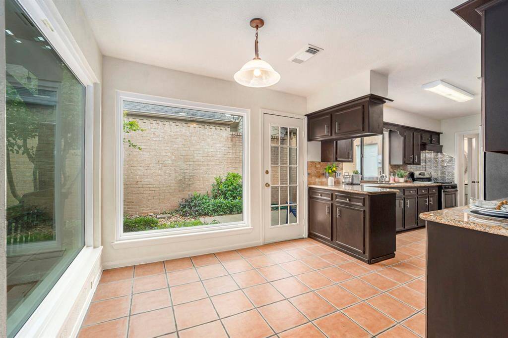 The breakfast room is a sunny, cheerful spot - thanks to oversized windows that bring in tons of natural light and offer a clear view of the beautifully landscaped backyard and covered patio.  It's the perfect place to enjoy your morning coffee while looking out at the garden. Whether you're starting your day or just taking a quiet break, this space feels connected to nature.