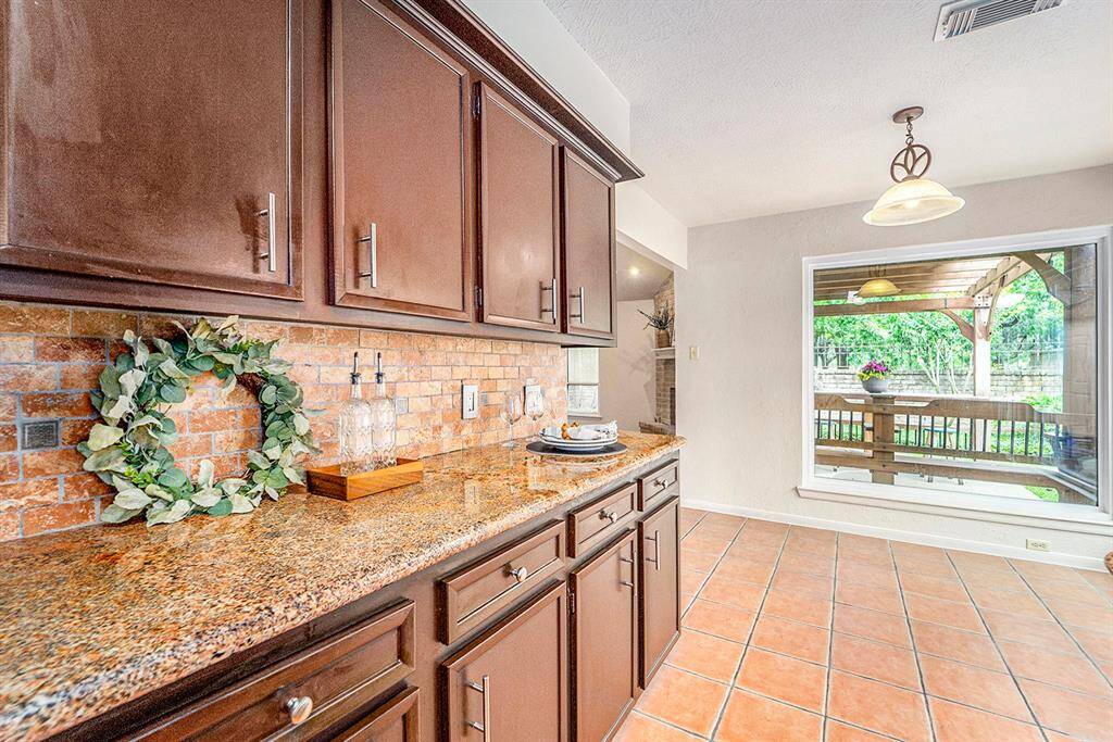 The kitchen is bright and welcoming, with plenty of natural light streaming through well-placed windows.  You've got a great view of the covered patio, making it easy to enjoy the scenery while cooking.