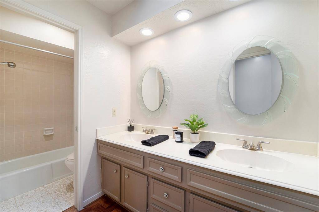 The secondary bedrooms bathroom is spacious and thoughtfully designed, featuring double sinks that make mornings a little easier- especially for kids or guests.  There's plenty of counterspace, storage underneath, and a separate area for the tub/shower and toilet.