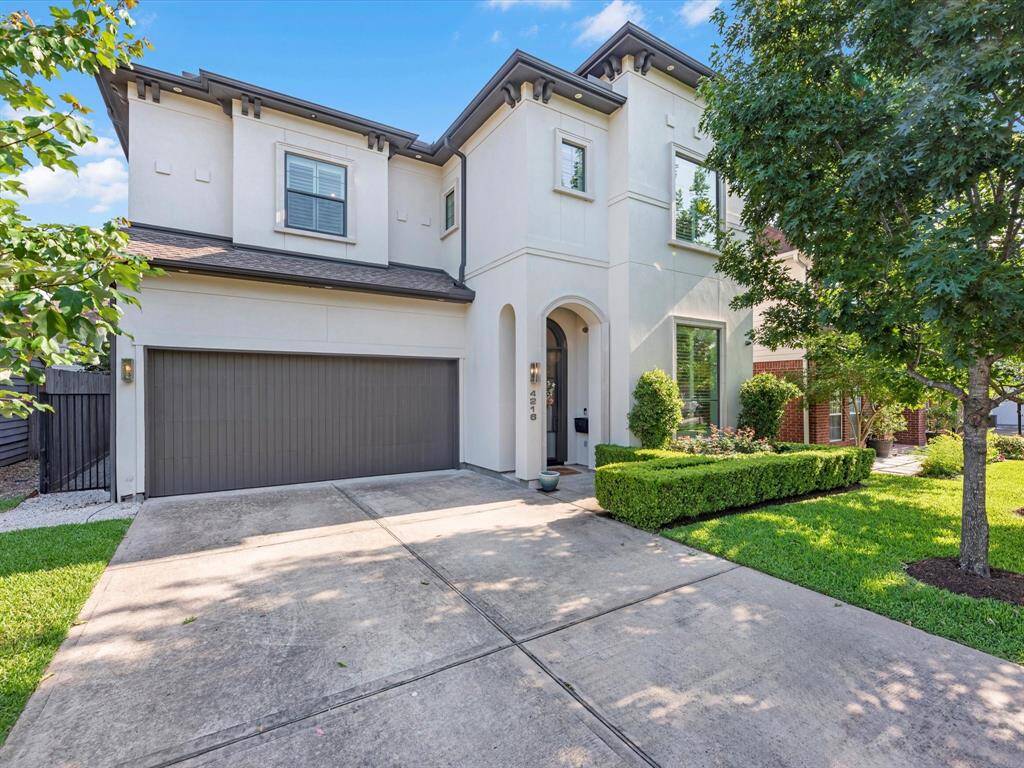 The welcoming entryway, framed by vibrant greenery and a stately front door, sets the tone for the refined interiors that await.