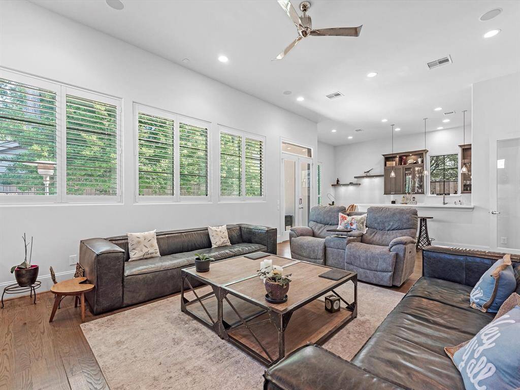 The sun-drenched living room boasts soaring ceilings and large picture windows that highlight the space’s open, airy feel.