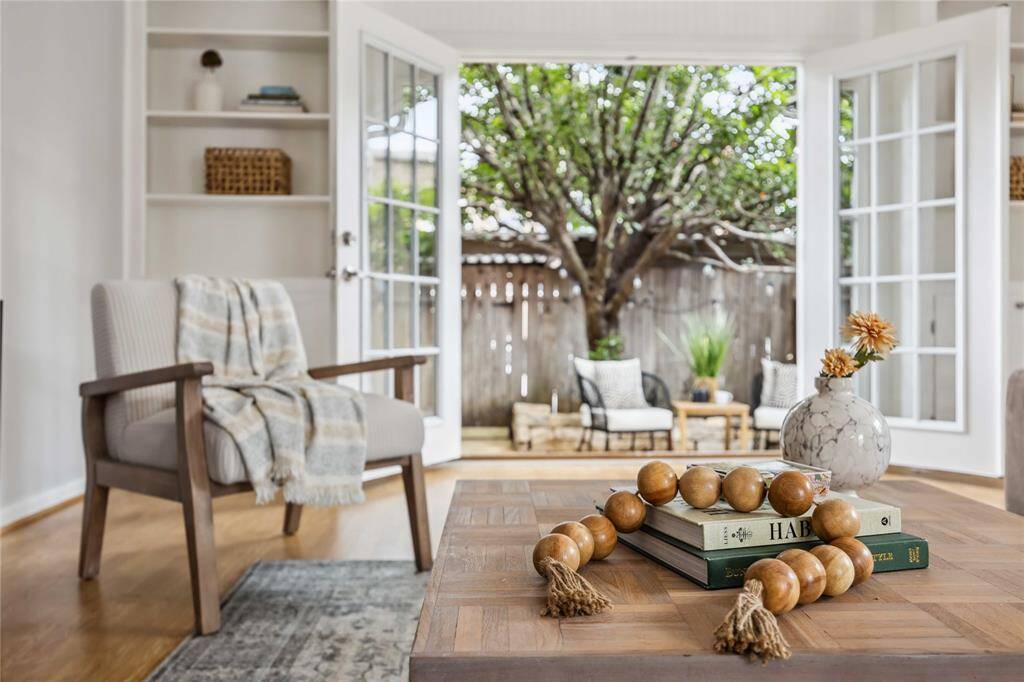 This photo demonstrates the perfection that is this home! From the floors and accents to the gorgeous shade tree perfectly framed by the French doors, you'll fall in love with this space.