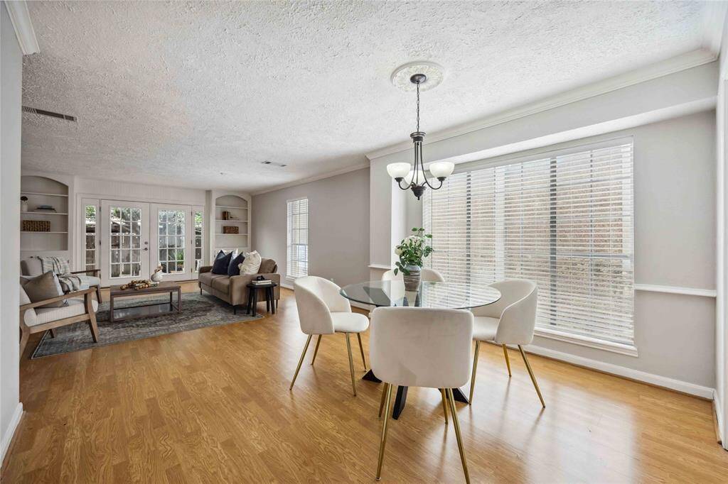 The room is filled with natural light that enhances the style and beauty as it is reflected in the beautiful engineered wood floors.