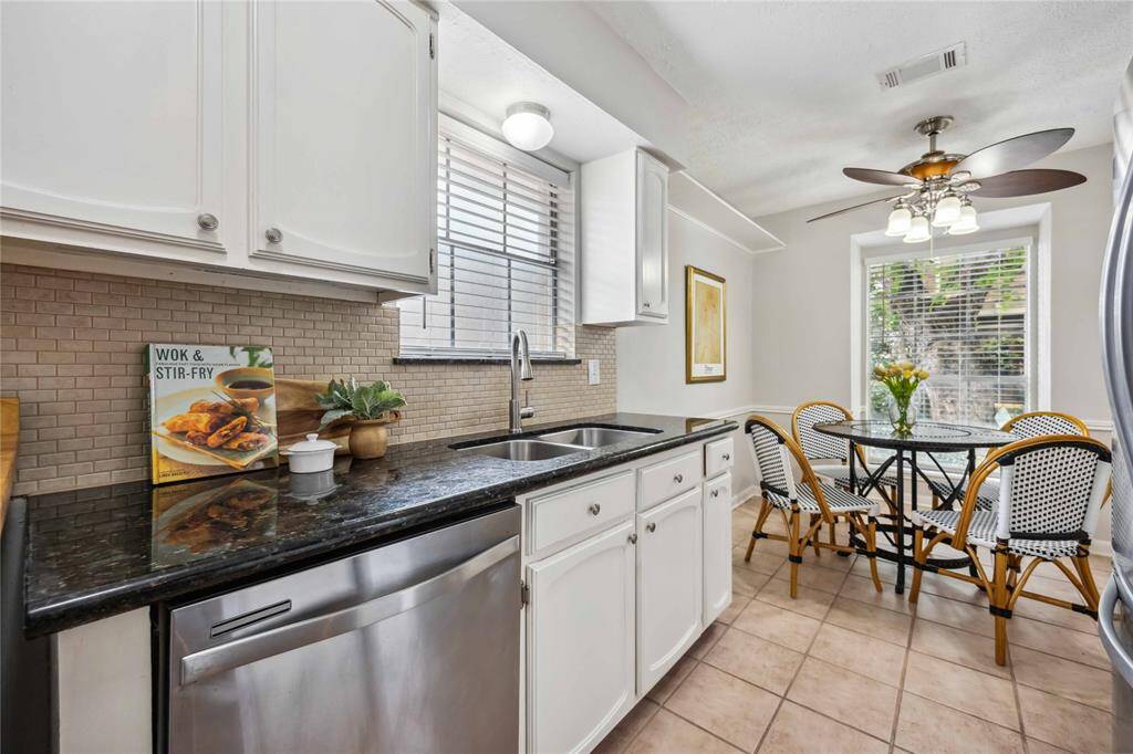 Granite counters, crisp white cabinets, and stainless steel appliances create a complementary color palette.