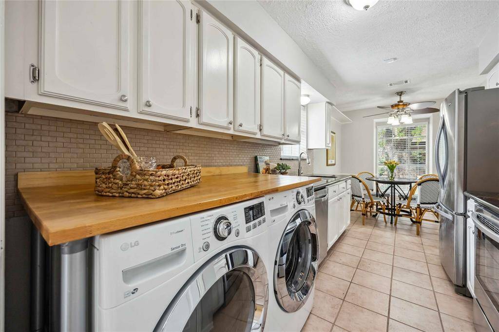 An additional butcher block counter rests above the front-loading washer and dryer.