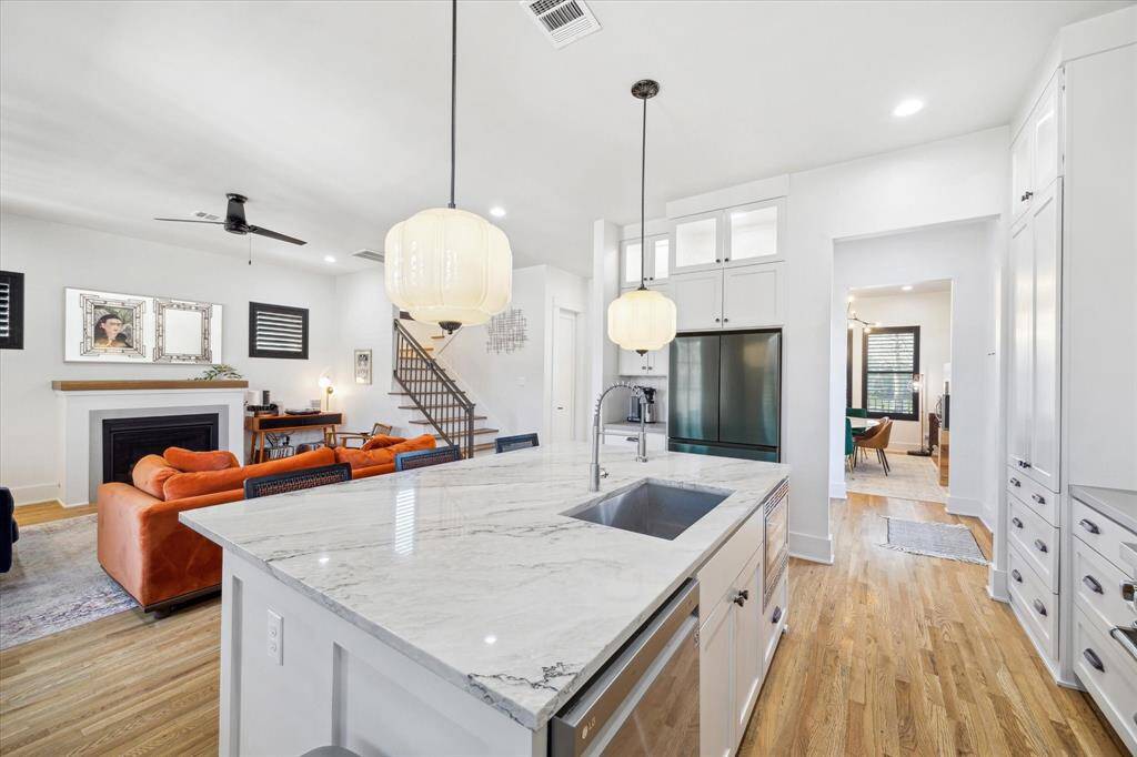 The oversized island, topped with gorgeous quartz, offers plenty of prep space and includes a deep sink, perfect for entertaining!
