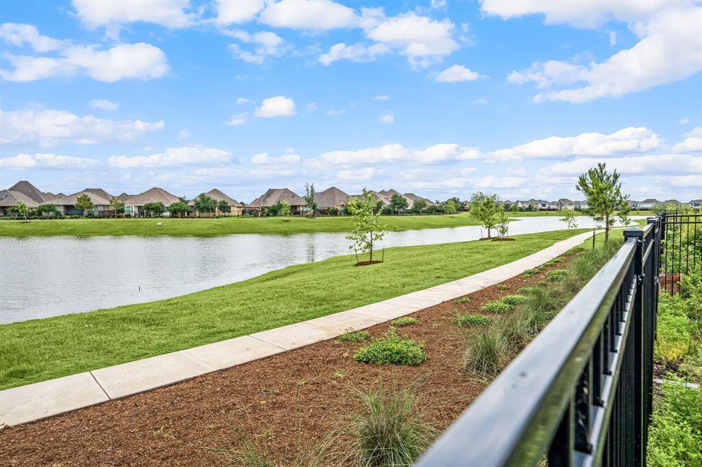 Peaceful water view framed by a wrought iron fence—beauty and openness combined