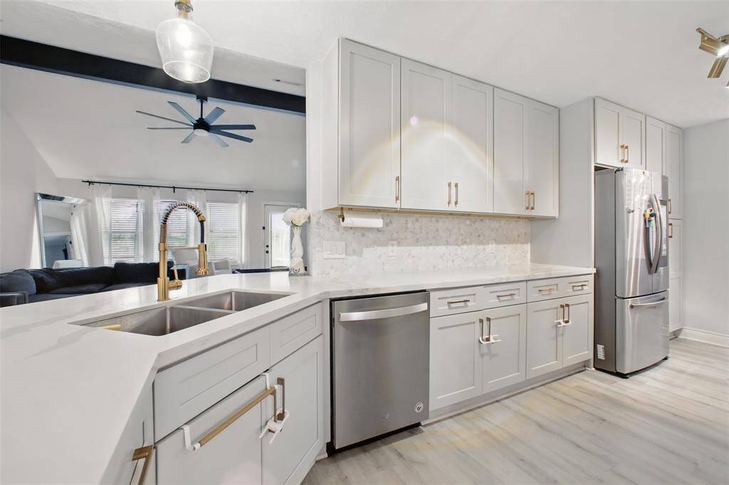 Double Stainless Steel Sinks & Modern Cabinetry with Gold Accents