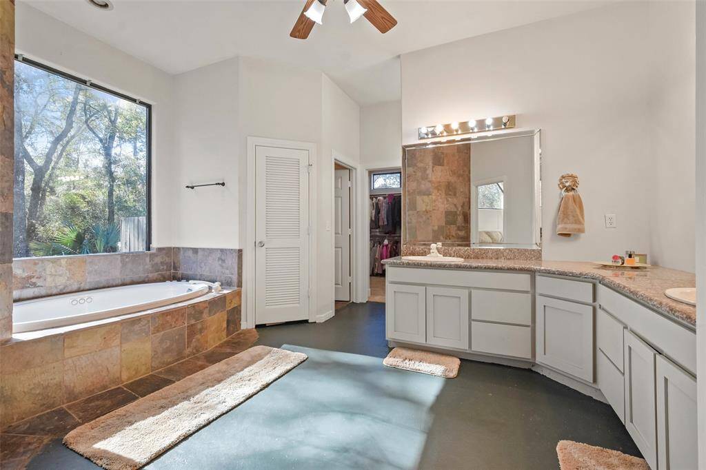 The primary bathroom features a jetted tub, walk-in shower & ample storage space.