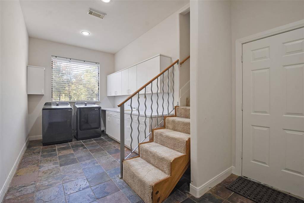 Spacious utility room with built-in cabinet space & a sink.