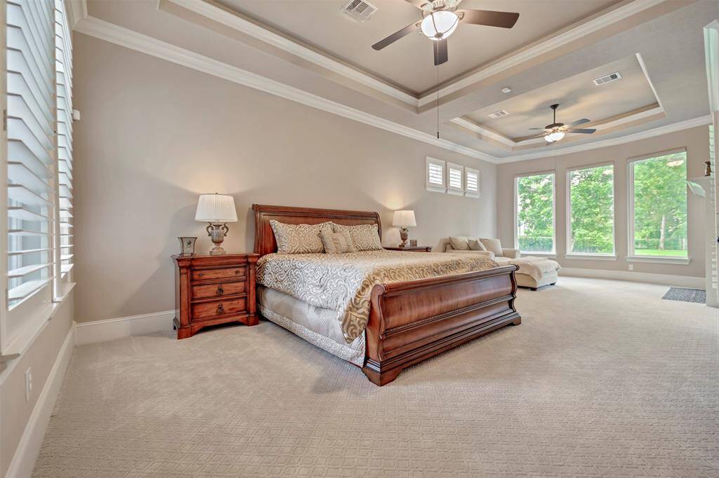 The primary bedroom features a wall of windows to flood the room with natural light.  Hunter Douglas Window coverings are all remote controlled so you can sleep in as much as you'd like and greet the morning at your pace.