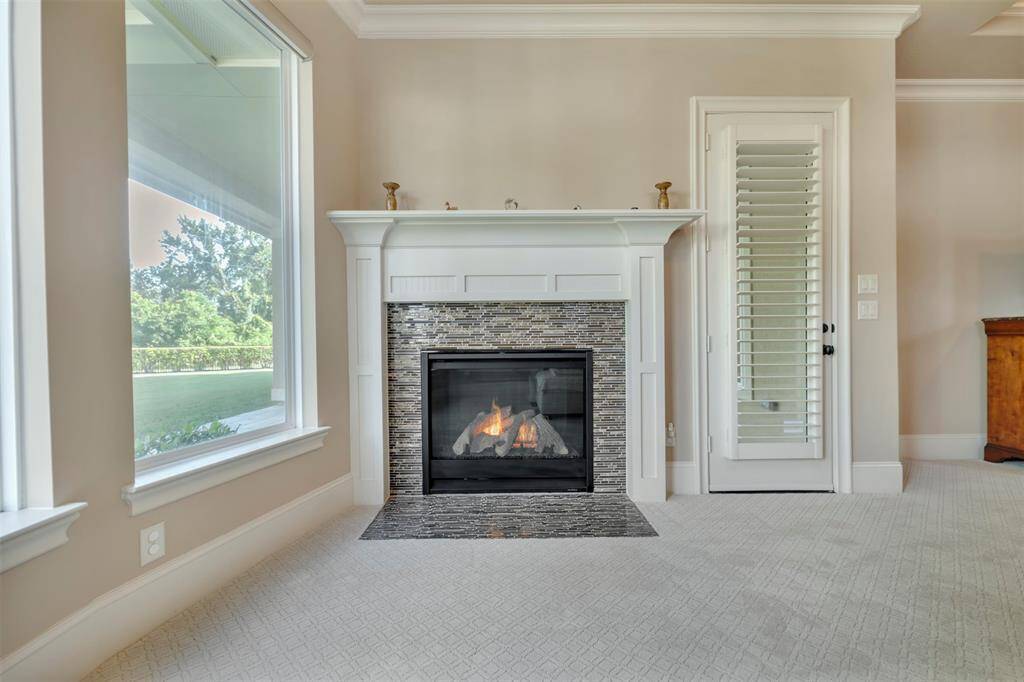 Primary bedroom boasts a sitting area with remarkable backyard views, a fireplace and door to the covered porch.  Morning coffee, anyone?