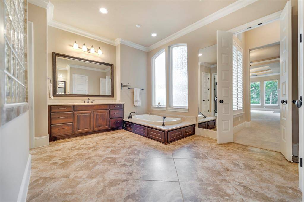 The primary bathroom is HUGE!  The sunken tub is adjacent to one vanity and closet.  The shower is in the middle and the second vanity and closet is opposite.