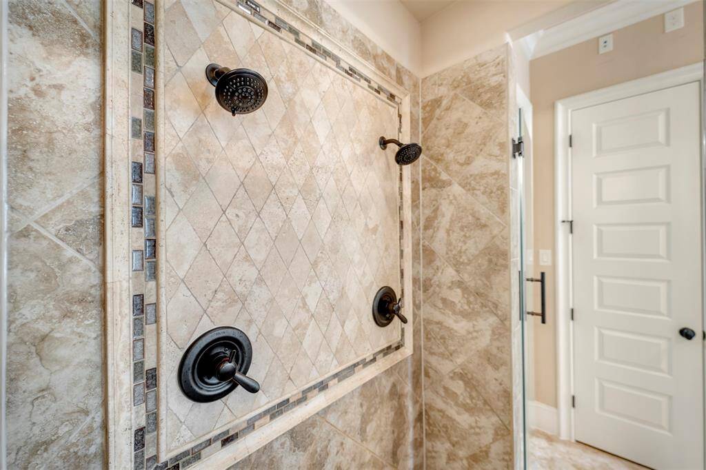 Take a quick peek into the primary bathroom shower!  Dual shower heads are a must in a home of this caliber!