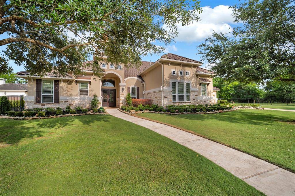 This fabulous home features a spacious front yard with well-maintained landscaping, a welcoming sidewalk, and a blend of stone and stucco exterior. Large windows and a grand entrance add to its curb appeal, surrounded by mature trees for added privacy.
