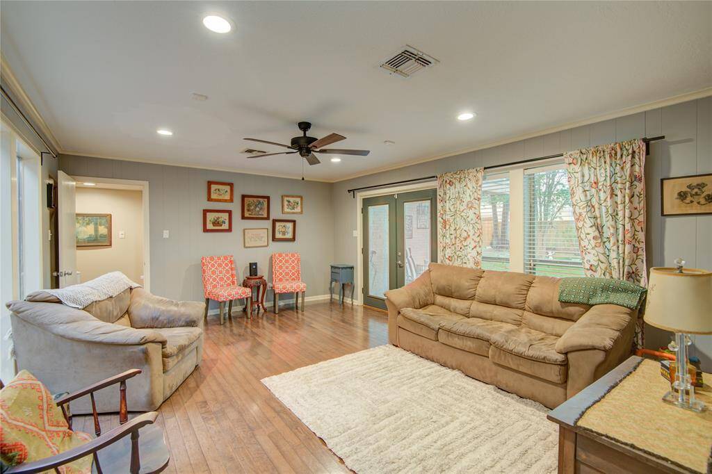 The spacious family room boasts oversized windows, elegant crown molding, recessed lighting, and French doors that open to the back patio.
