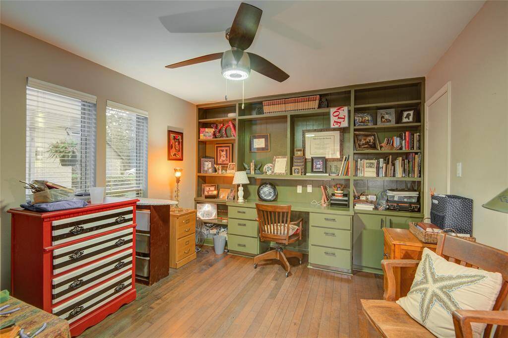Versatile secondary bedroom currently serves as a home office, featuring a walk-in closet and serene views of the front courtyard.