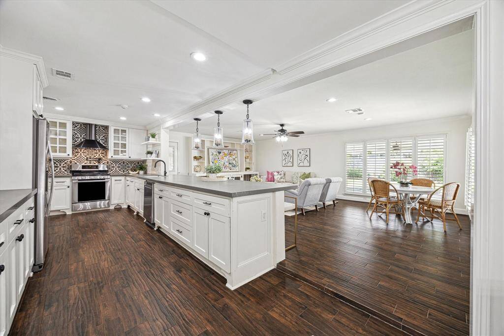The kitchen and living room are open and spacious. On the other side of the refrigerator is the door leading to the garage.
