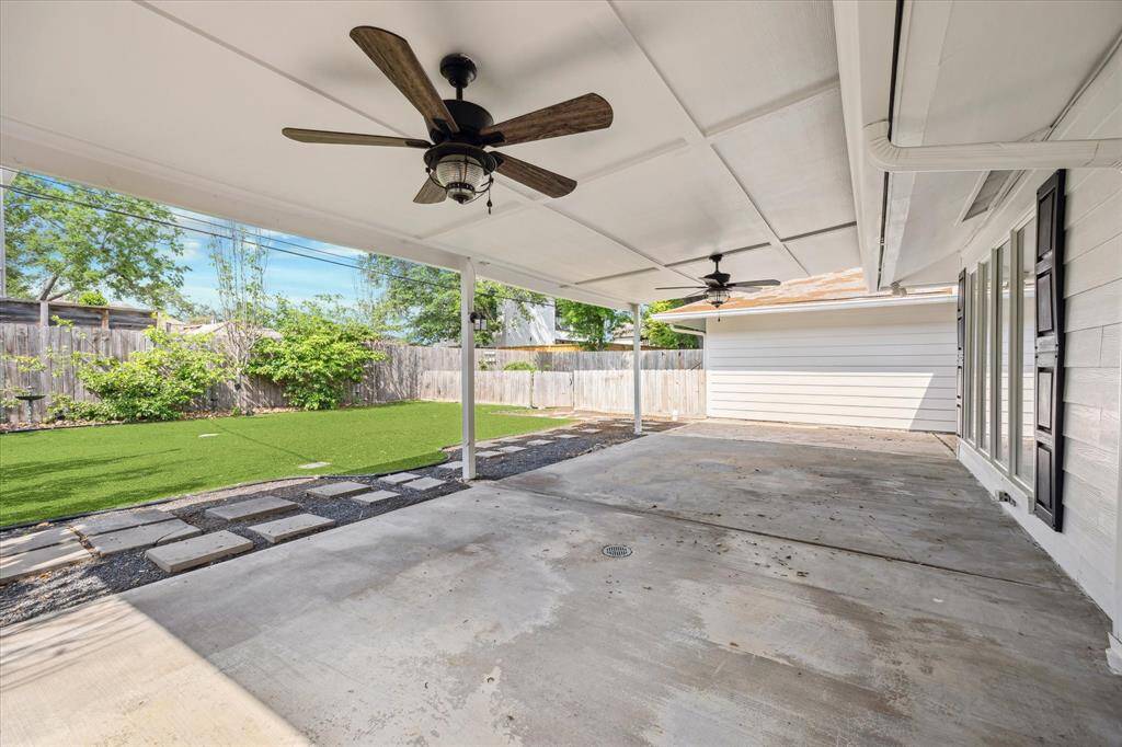 Large outdoor patio is covered and overlooks the turfed backyard.