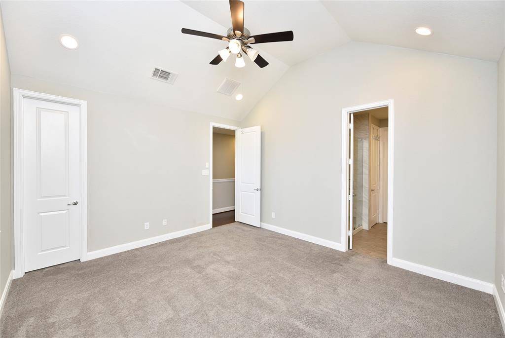 Another view of the primary bedroom features an additional closet and impressive raised ceilings.