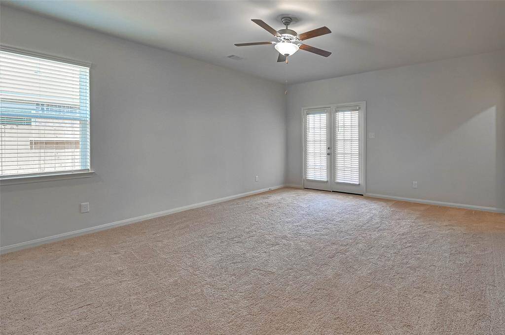 Carpeted living area with doors leading to the backyard.