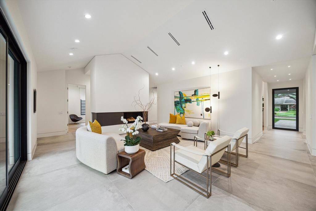The space is beautifully lit with recessed lighting, and a stunning fireplace with an air-cooled steel wood-burning flue serves as a captivating focal point.