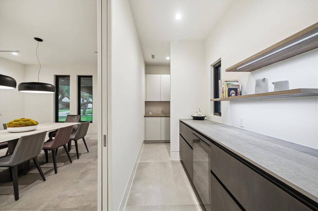 Discover the convenience of a private butler's pantry situated behind the formal dining room. It offers ample counter and storage space with self-closing drawers and features a climate-controlled fridge by MIELE.