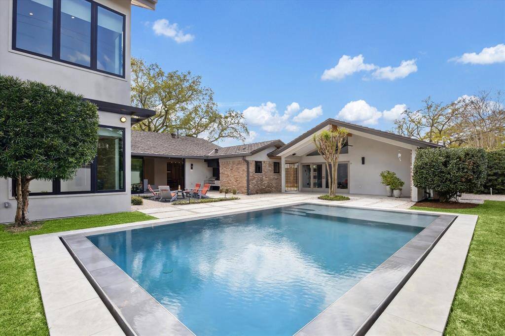 A breathtaking infinity-edge heated pool with light, perfectly connecting with the cabana and patio.