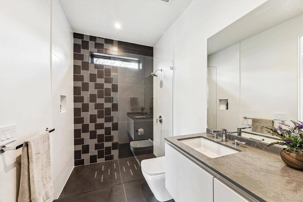 Modern and sleek secondary full-size bathroom with a walking shower and wall accent tile CAVA by LucidiPevere Collection and European-Style cabinetry by LEICHT