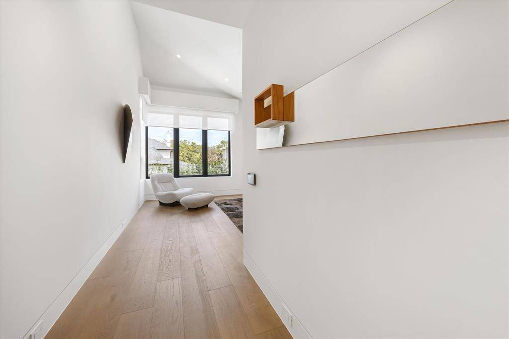 Primary Bedroom hallway with high ceilings, leading to a cozy sitting area by large windows.