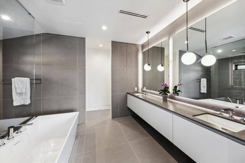 Pristine Primary Bath with a soaking tub by SIGNATURE HARDWARE, 3/8" thick frameless glass shower panels, and vanity by LEICHT.