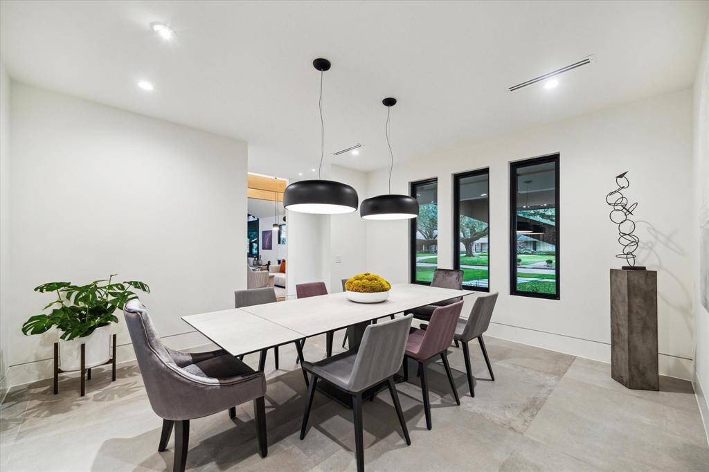 Formal Dining Room features large windows that provide natural light, and dimmable double pendant light fixtures made by FLOS Smithfield.