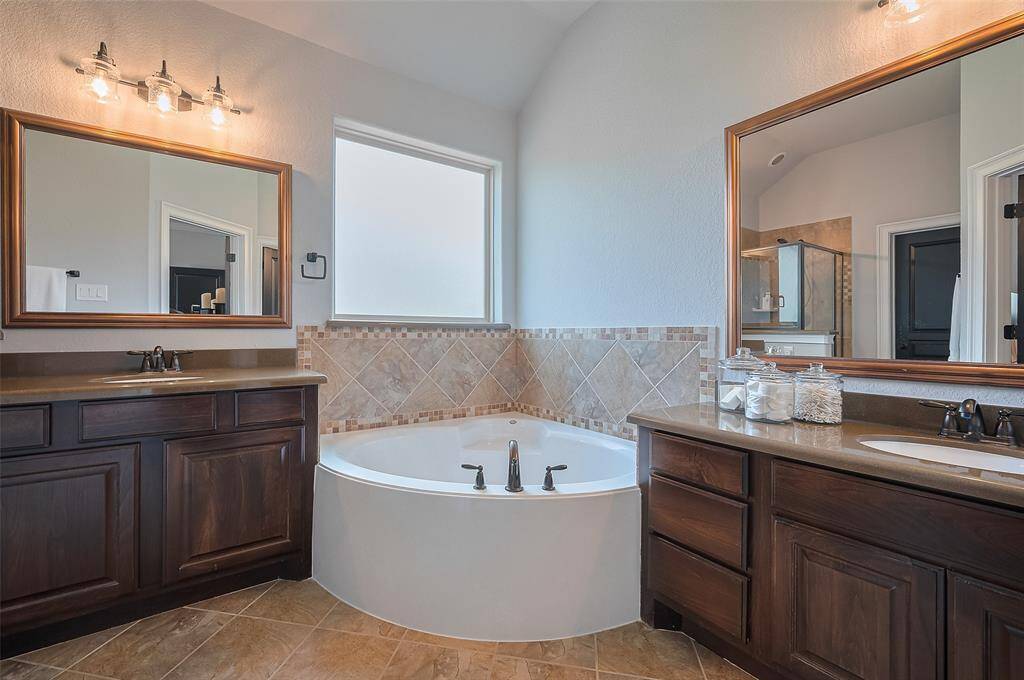His & Her Vanities with a large soaking tub in the middle.