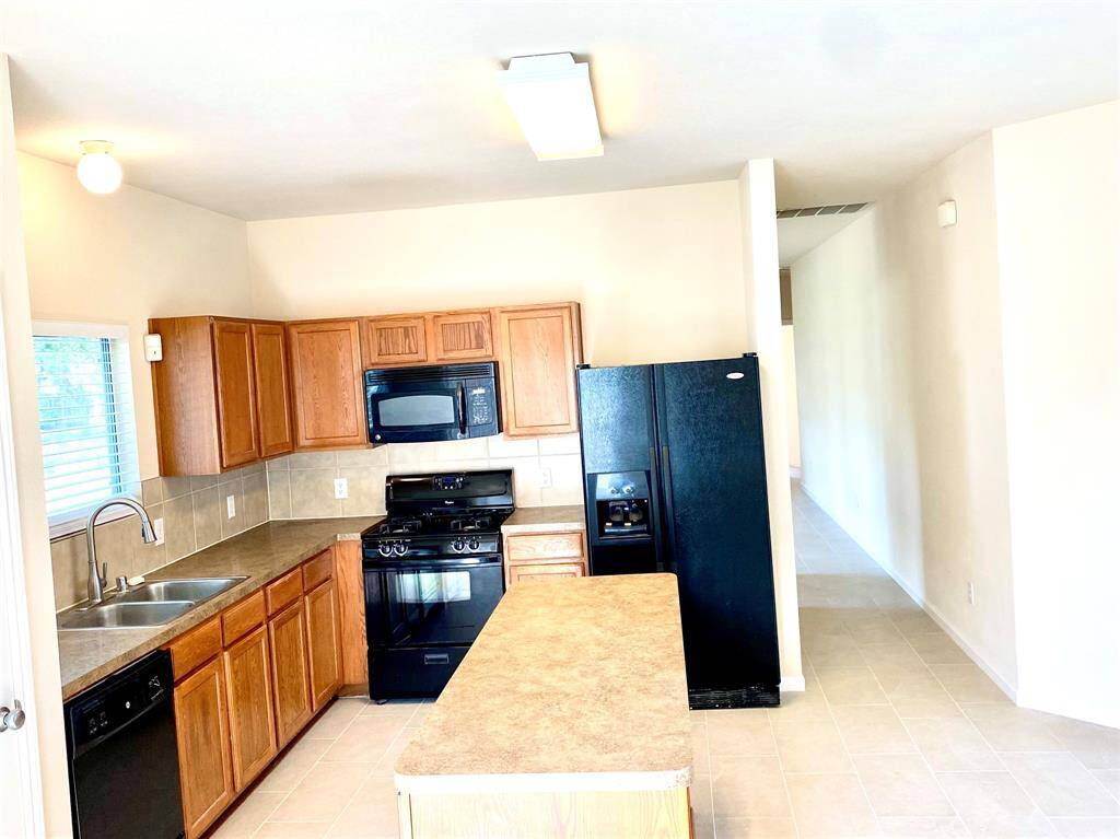 The convenient island offers both storage and work space, making the kitchen green even larger than it is