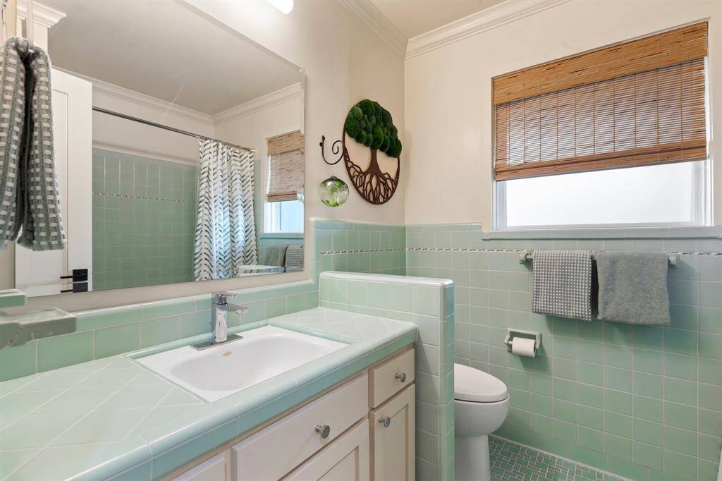 Full bath # 2 features restored mid-century tile work with updated cabinet faces and fixtures.