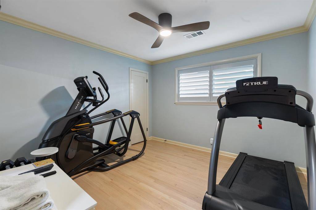 Bedroom # 3 features refinished wood floors, window shutters and modern ceiling fan.