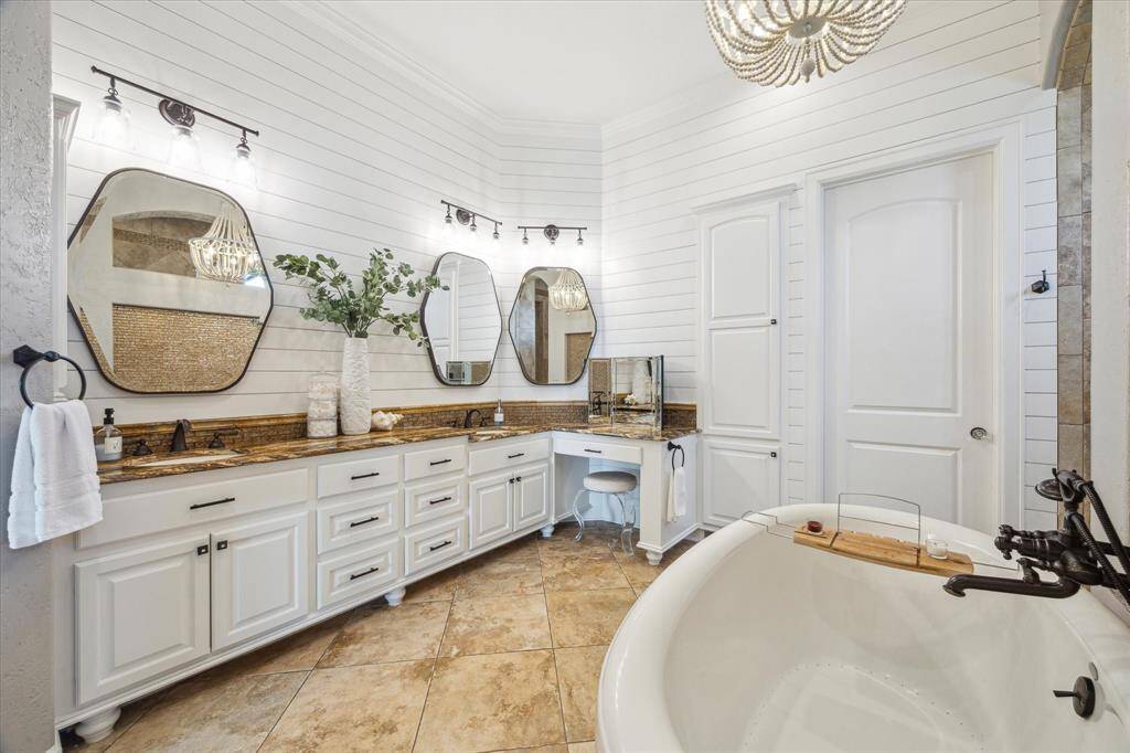 Primary ensuite features dual sinks, freestanding soaking tub surrounded by a bright and charming aesthetic.